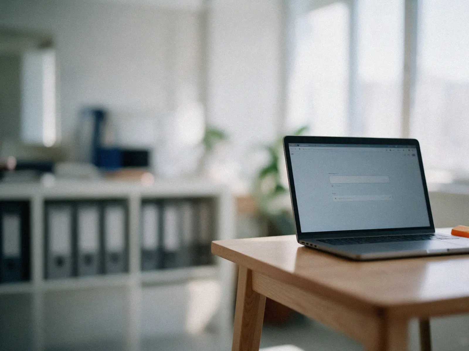 Laptop mit Suchfeld und Antwort, im Hintergrund ein Regal mit Aktenordnern